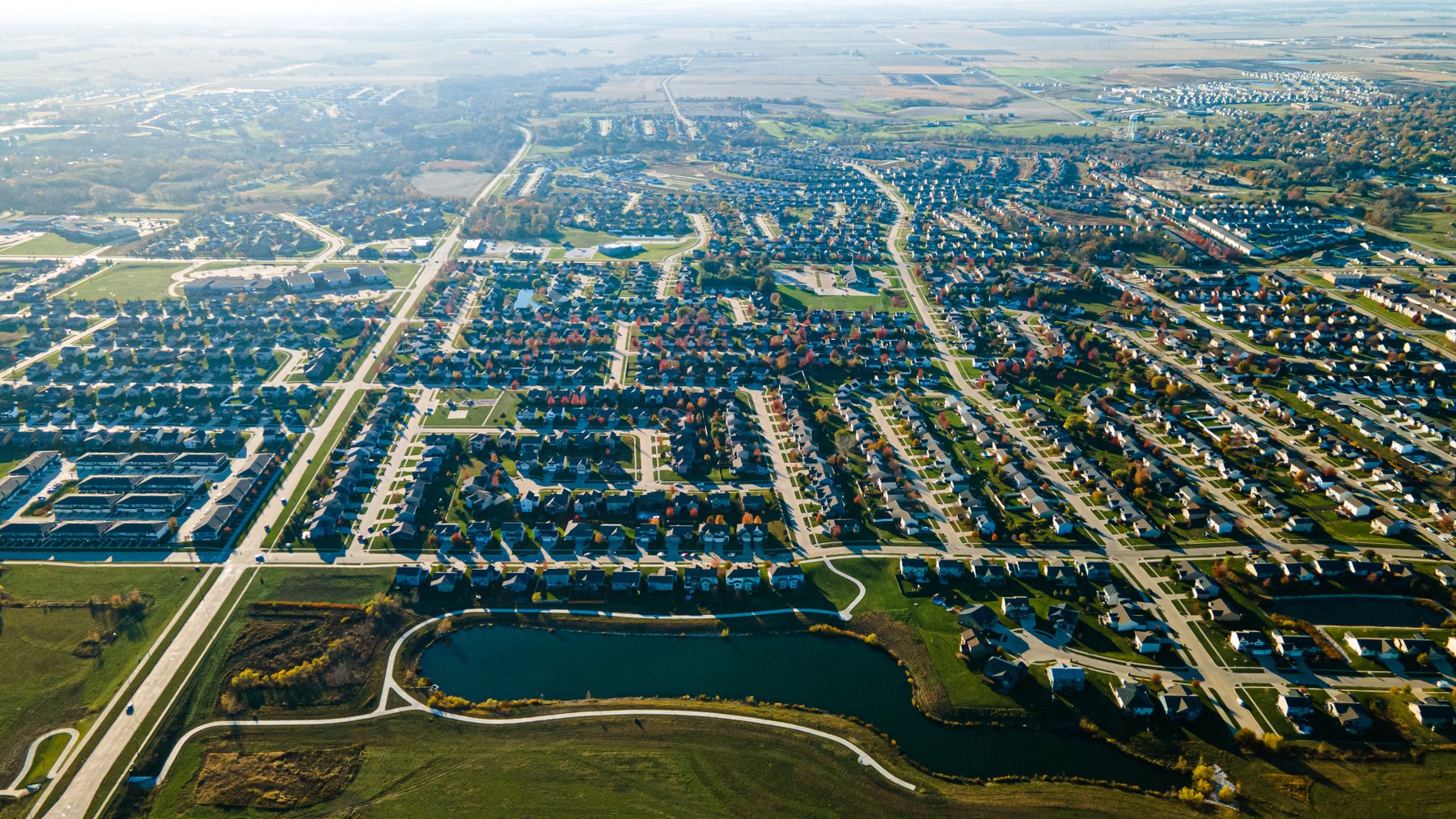 Aerial drone photo showing roads, neighborhoods, fields, ponds, and land layout from above